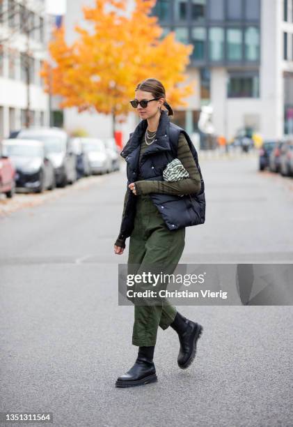 Jacqueline Zelwis is seen wearing nwear vest in black, green Ravens Saloner Shirt, G Star pants, black Copenhagen Studios Boots, Tory Burch bag,...