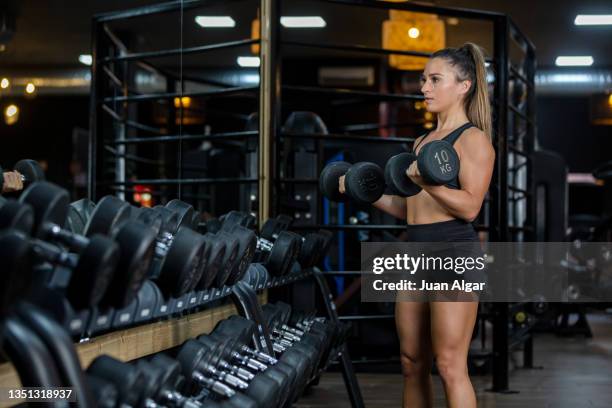 athlete doing biceps curl with both arms in a sports center - musculation des biceps photos et images de collection