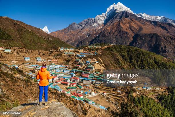 woman looking at namche bazaar from above, mount everest national park, himalaya, - namche bazaar stock pictures, royalty-free photos & images
