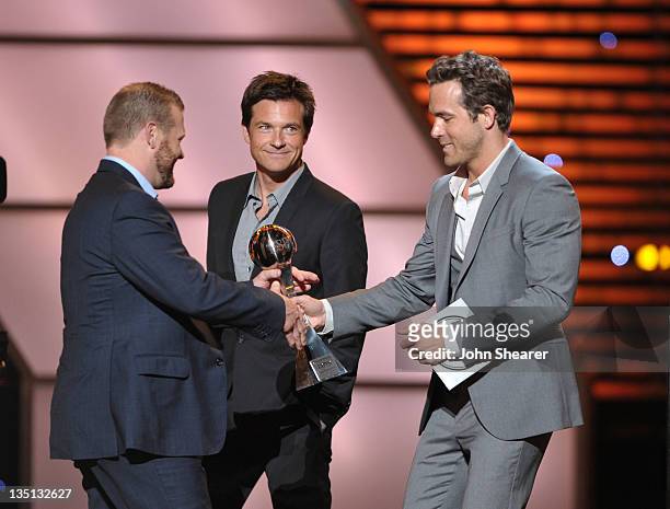 Tim Thomas of the NHL's Boston Bruins accepts the award for 'Best Championship Performance' onstage from presenter Ryan Reynolds and Jason Bateman at...