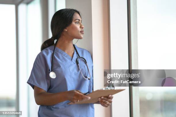 le médecin fait une pause dans le couloir - blouse blanche femme photos et images de collection