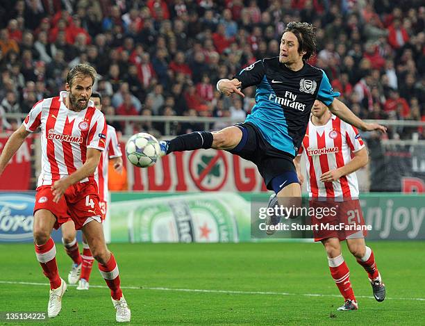 Tomas Rosicky of Arsenal jumps above Olof Mellberg of Olympiacos during the UEFA Champions League Group F match between Olympiacos FC and Arsenal FC...