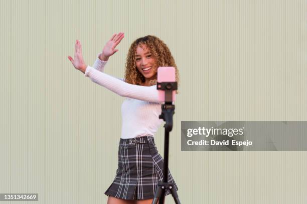 cheerful hispanic woman going live on smartphone - filming fotografías e imágenes de stock