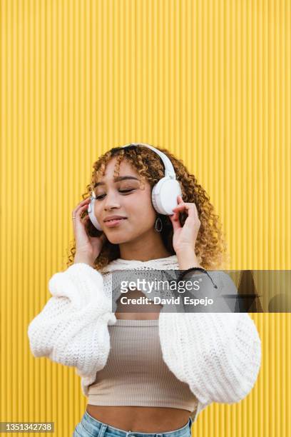 stylish hispanic woman listening to music - headphones stock pictures, royalty-free photos & images