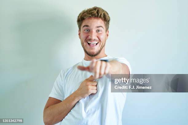 portrait of man pointing on white background - plain t shirt stock pictures, royalty-free photos & images