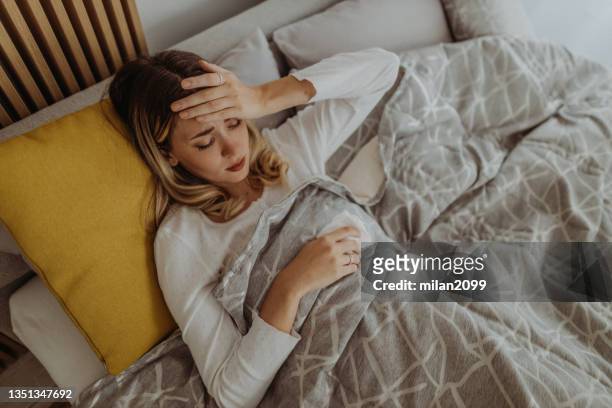 virus - caucasian woman sick in bed coughing stock pictures, royalty-free photos & images