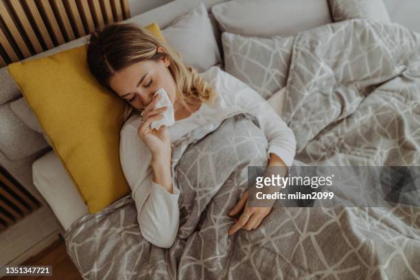 virus - caucasian woman sick in bed coughing stock pictures, royalty-free photos & images