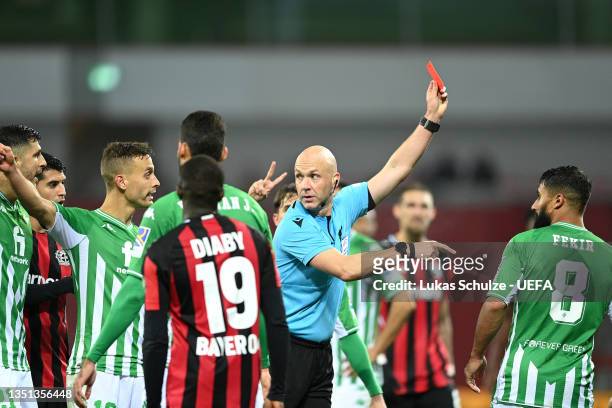 Referee Anthony Taylor shows a red card to Nabil Fekir of Real Betis during the UEFA Europa League group G match between Bayer Leverkusen and Real...