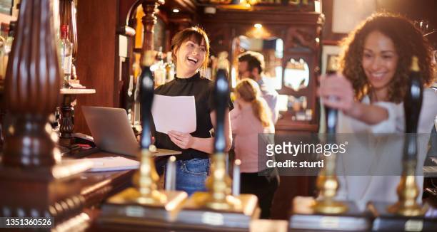 happy bar manager dealing with accounts - happy hour stockfoto's en -beelden