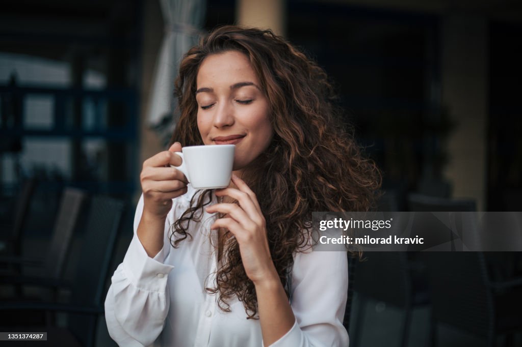 Frau, die Cappuccino in einem Café genießt