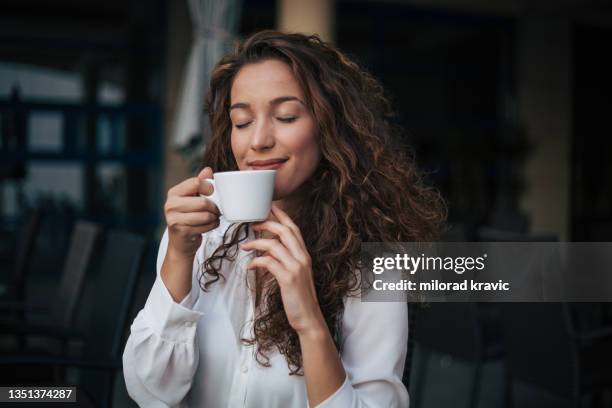 femme dégustant un cappuccino dans un café - goûter photos et images de collection