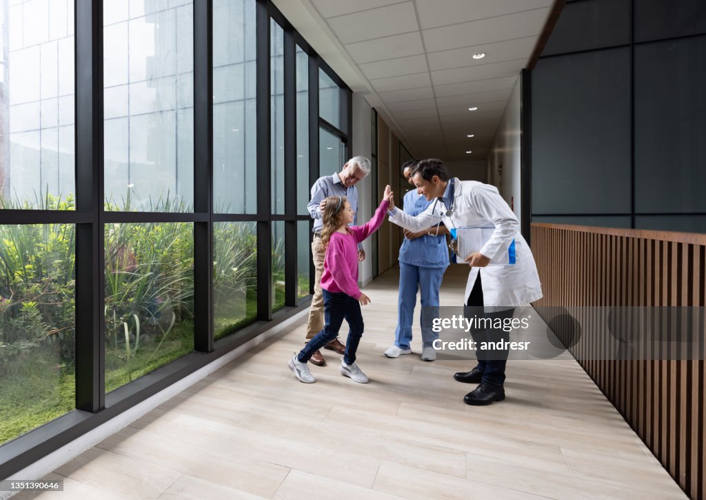 Doctor giving a high-five to a girl at the hospital