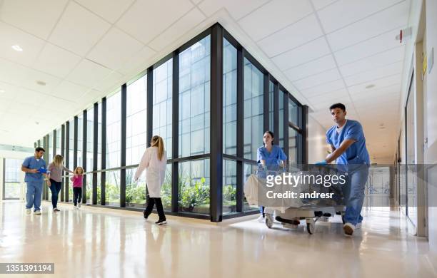 ärzte, die patienten im krankenhaus unterstützen - korridor stock-fotos und bilder