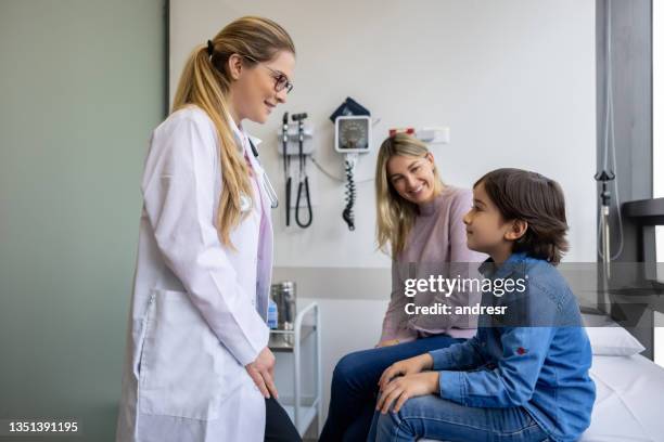 paciente joven hablando con un médico en su consultorio - practicing fotografías e imágenes de stock