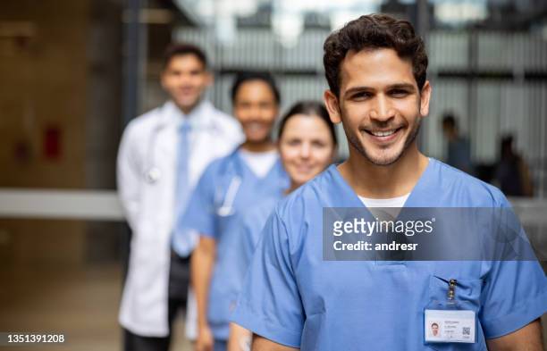 glückliche gruppe von ärzten, die im krankenhaus lächeln - the resident screening stock-fotos und bilder
