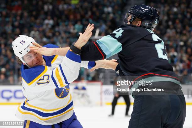 John Hayden of the Buffalo Sabres and Jamie Oleksiak of the Seattle Kraken fight during the first period on November 04, 2021 at Climate Pledge Arena...