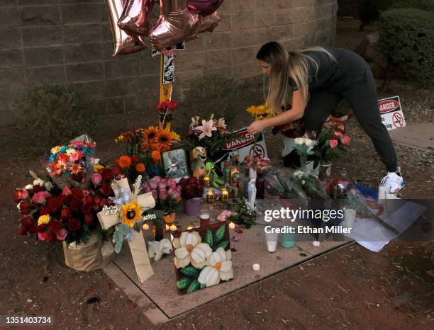 Marissa Carmello of Nevada adjusts flowers at a roadside memorial near the site where Tina Tintor and her dog Max died in a vehicle crash involving...