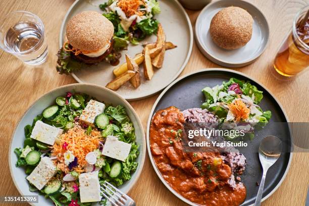 scene at a table with a couple enjoying lunch at a vegan cafe. - mittagspause stock-fotos und bilder