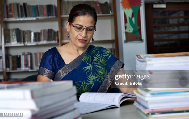 teachers writing and reading books in library - publication stock pictures, royalty-free photos & images