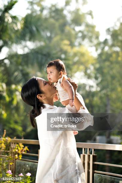 young woman playing with her baby son - indian mother stockfoto's en -beelden