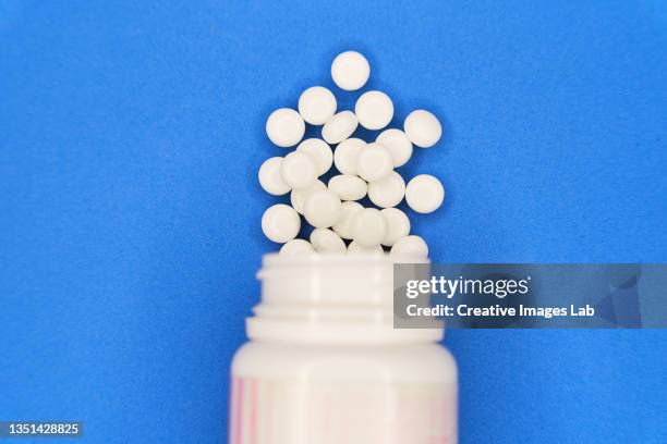 tablets spill out of the plastic container - ácido acetilsalicílico - fotografias e filmes do acervo