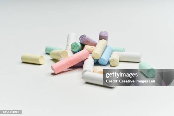 small broken pieces of colored chalk sticks on white background. - bâton de craie photos et images de collection