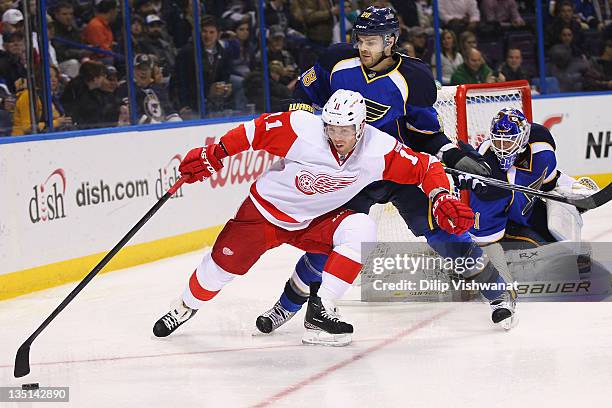 Daniel Cleary of the Detroit Red Wings holds Carlo Colaiacovo of the St. Louis Blues off the puck at the Scottrade Center on December 6, 2011 in St....