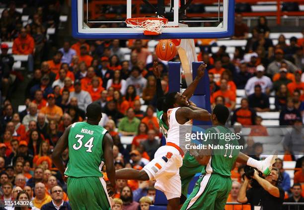 Dion Waiters of the Syracuse Orange collides with DeAndre Kane of the Marshall Thundering Herd as teammates Yous Mbao and Nigel Spikes look on during...