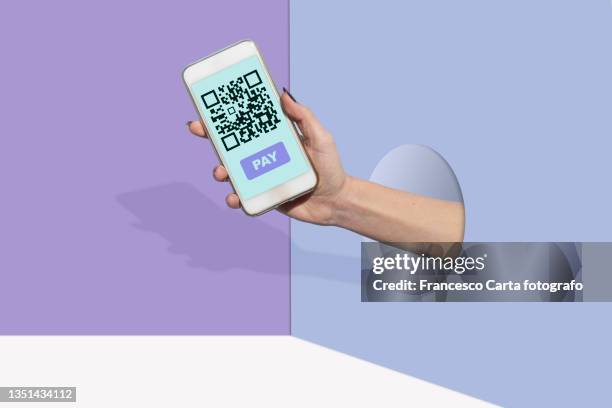 woman's hand shows her smartphone with qr code payment - woman coding stockfoto's en -beelden