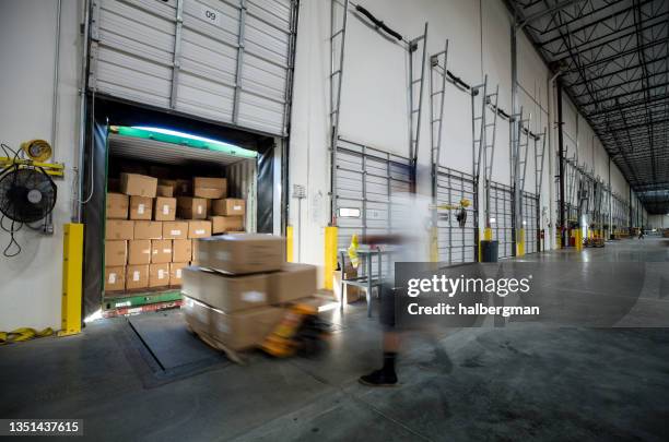 worker unloading truck at warehouse loading dock - logistica imagens e fotografias de stock