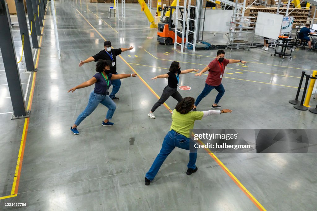 Workers Doing Stretching Exercises in Warehouse