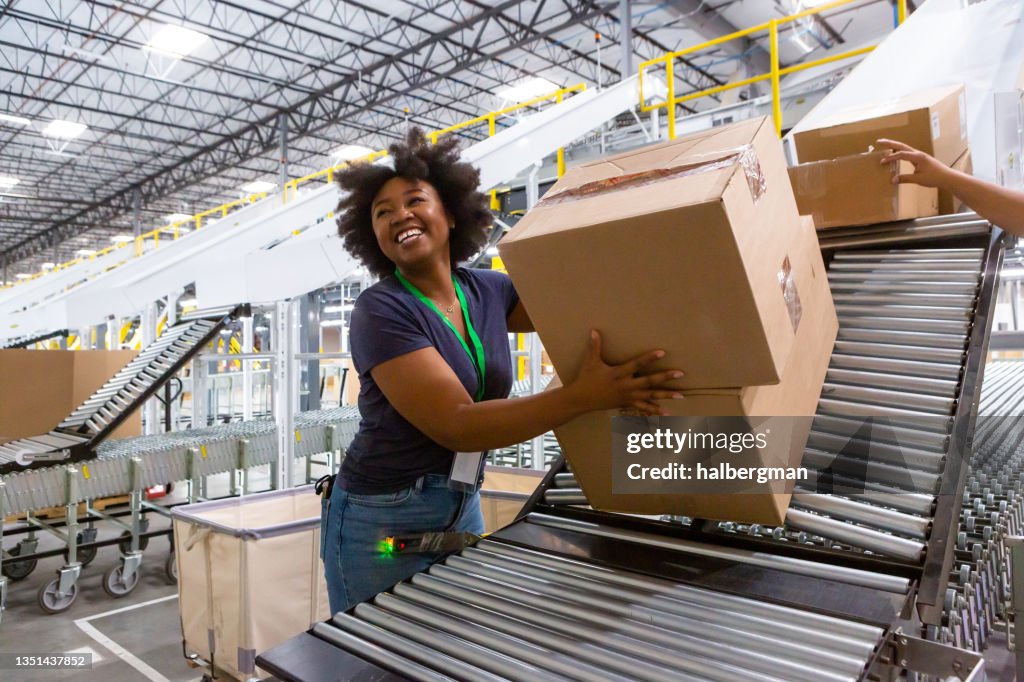 Fröhlicher Lagermitarbeiter verlädt Kisten in LKW