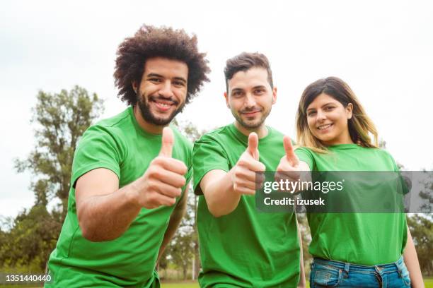 confident environmentalists showing thumbs up - klimaatactivist stockfoto's en -beelden