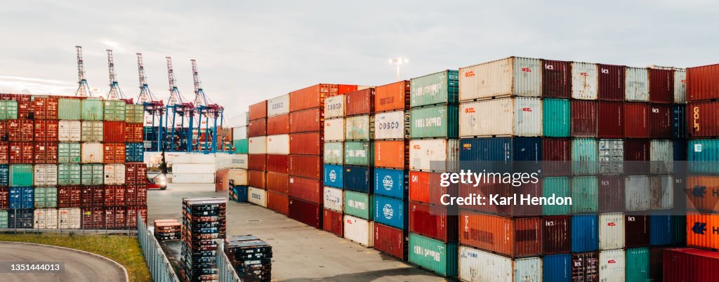 An aerial view of shipping containers stacked up in a port - stock photo