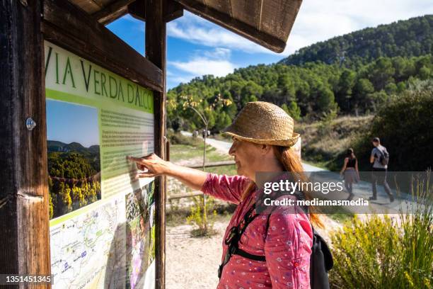 a hiker consults an information panel on the font roja route in alcoi, spain. - wilderness font stock pictures, royalty-free photos & images