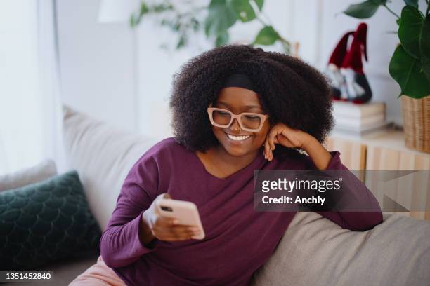 jovem sorridente usando as redes sociais em seu telefone. conceito de namoro online - big beautiful women - fotografias e filmes do acervo