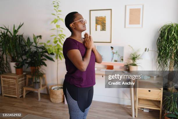 young woman practicing yoga at home on video conference - sun salutation stock pictures, royalty-free photos & images