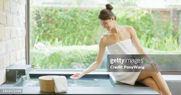 woman holding hot spring water - woman with towel spa stock pictures, royalty-free photos & images