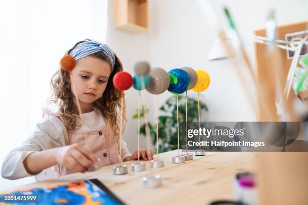 little girl making a solar system model at home, homeschooling. - sistema solar fotografías e imágenes de stock