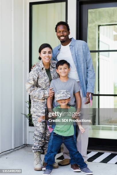 female soldier poses for photo with her family - military home stock pictures, royalty-free photos & images