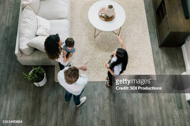 high angle view real estate agent showing house to family - real estate agent stock pictures, royalty-free photos & images