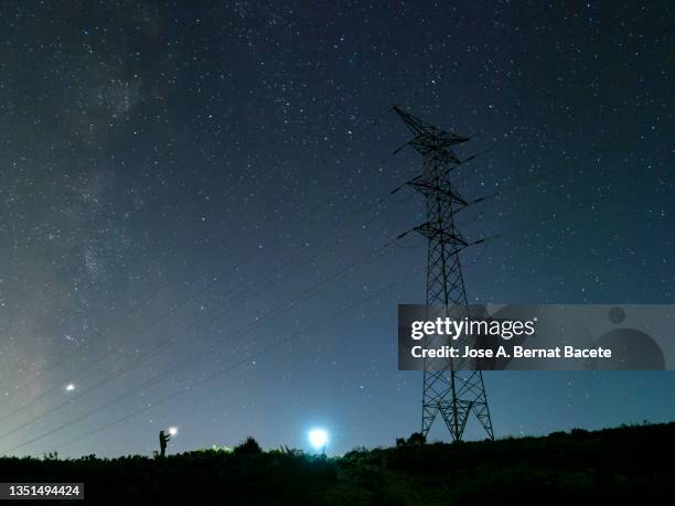 electricians repairing a high voltage electrical tower at night in the mountains. - utility pole stock pictures, royalty-free photos & images