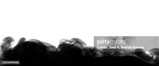 full frame of black smoke cloud floating on the ground on a white background. - black smoke stock pictures, royalty-free photos & images