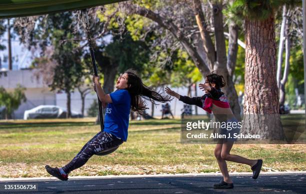 Sun Valley, CA Kids play on a swing in the shade amidst a sunny, hot summer day at the Sun Valley Recreation Center in Sun Valley Tuesday, June 27,...