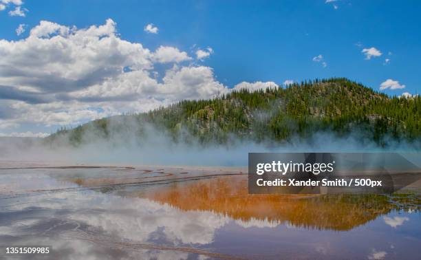 scenic view of hot spring against cloudy sky,yellowstone national park,united states,usa - smokey mountain spring stock pictures, royalty-free photos & images