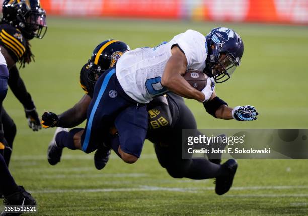 Chandler Worthy of the Toronto Argonauts stretches fro extra yards after being hit by Ja'Gared Davis of the Hamilton Tiger-Cats at Tim Hortons Field...