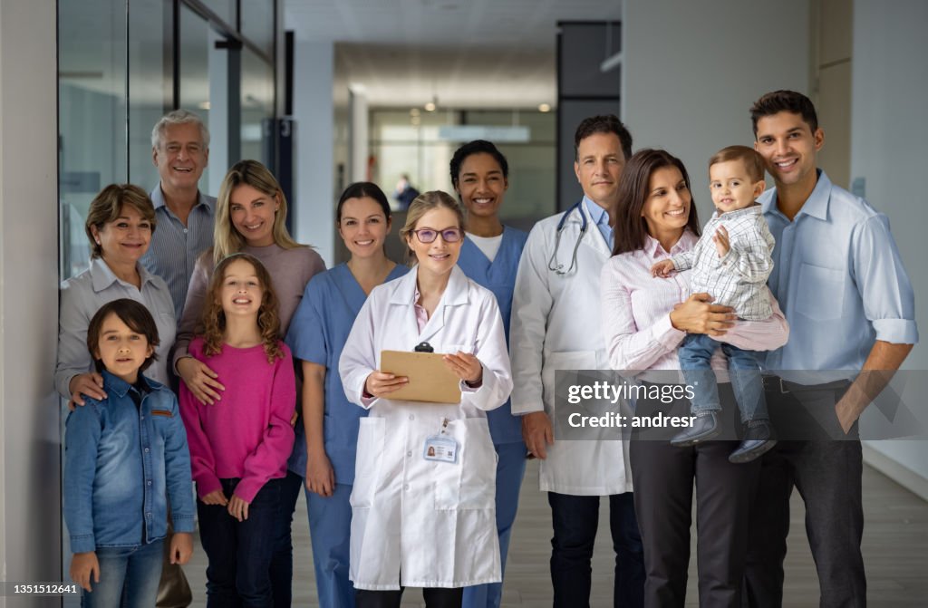 Happy group of doctors and patients at the hospital