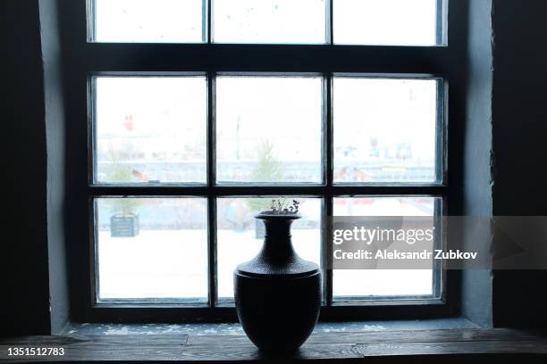 in a glass or ceramic vase there are withered purple flowers, twigs and dried flowers. nature wallpaper blurred background. art photography, exhibition or still life. vase on the windowsill, against the background of the window. - cesar flores fotografías e imágenes de stock