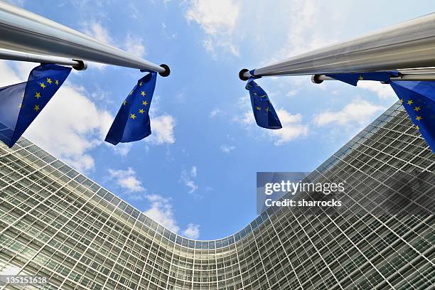 eu flags outside european commission building in brussels - eec headquarters stock pictures, royalty-free photos & images