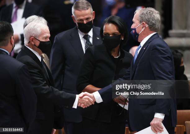 Former President George W. Bush shakes hands with former CIA director Robert Gates as former Secretary of State Concoleezza Rice and former Joint...